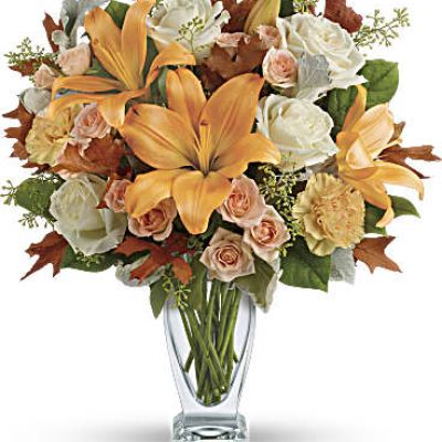 Capture the natural beauty of autumn with this stunning arrangement of lilies and roses in an elegant glass vase, sure to brighten any fall day.
This beautiful arrangement features white and peach roses, peach asiatic lilies and peach carnations and is finished with dusty miller, seeded eucalyptus, brown oak leaves and lemon leaf.